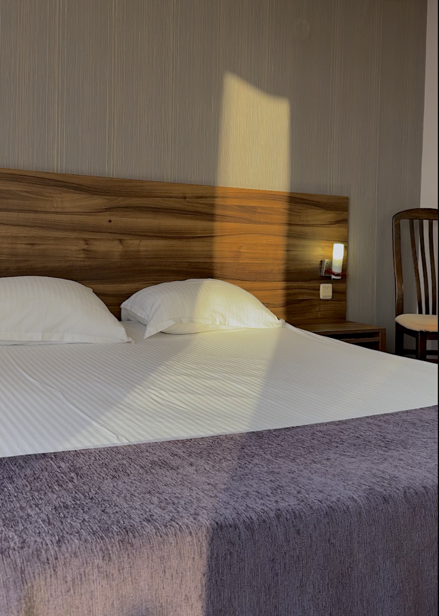 Cama do Hotel Ellinis com luz do fim de tarde
