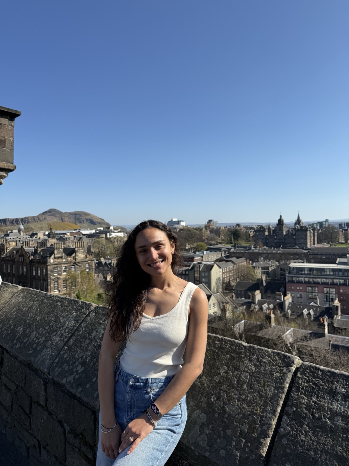 Fran sorrindo com a vista do Castelo de Edimburgo ao fundo
